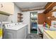 Laundry room with washer, dryer, shelves, and a view into a garage with a golf cart at 1908 Canterbury Ln # 28, Sun City Center, FL 33573