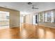 Open-concept living room with hardwood floors, fan, and windows with drapes at 1908 Canterbury Ln # 28, Sun City Center, FL 33573