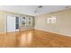 Spacious room featuring wood floors, ceiling fan, and views of the exterior at 1908 Canterbury Ln # 28, Sun City Center, FL 33573