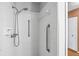 Shower area featuring white tiles and chrome fixtures, including a shower head and grab bars at 1908 Canterbury Ln # 28, Sun City Center, FL 33573