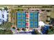 An aerial view displays multiple tennis courts surrounded by lush greenery and a parking area at 1908 Canterbury Ln # 28, Sun City Center, FL 33573