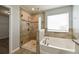 Well-appointed bathroom with a tiled shower, soaking tub, and modern fixtures at 19200 Roseate Dr, Lutz, FL 33558