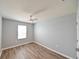 Cozy bedroom featuring neutral paint, wood-look flooring, a ceiling fan, and a bright window at 19200 Roseate Dr, Lutz, FL 33558