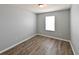 Minimalist bedroom features neutral walls, wood-look flooring, a window, and ample space at 19200 Roseate Dr, Lutz, FL 33558