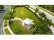 Aerial view showcasing a dog park with a covered picnic area, walking path, and agility equipment at 19200 Roseate Dr, Lutz, FL 33558