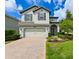 Charming two-story home with a brick paver driveway and lush green lawn at 19200 Roseate Dr, Lutz, FL 33558
