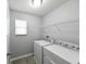 Efficient laundry room with shelving, window, and modern washer and dryer at 19200 Roseate Dr, Lutz, FL 33558
