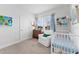 Bedroom room with white crib, comfortable chair, and natural light from the window at 202 S Tampania Ave # 3, Tampa, FL 33609