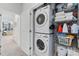 Functional laundry room with stacked washer and dryer, plus shelving for cleaning supplies at 202 S Tampania Ave # 3, Tampa, FL 33609