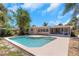 Backyard view of a refreshing in-ground pool with a spacious concrete deck at 204 Cove Ct, Clearwater, FL 33756