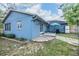 Backyard view with a patio, garden area, blue exterior, and well-maintained lawn at 2308 Rio Cir, Spring Hill, FL 34608