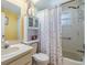 Bright bathroom with a tub and shower combination, cabinet, and stylish floral shower curtain at 2308 Rio Cir, Spring Hill, FL 34608