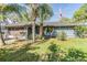 Charming single story home with blue exterior, mature trees, and manicured lawn at 2308 Rio Cir, Spring Hill, FL 34608
