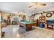 A spacious living room features a pool table, tile floor, and lots of room for entertaining at 2308 Rio Cir, Spring Hill, FL 34608