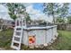 View of backyard above ground pool with ladder and surrounding wooden fence at 2308 Rio Cir, Spring Hill, FL 34608