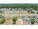 Aerial view of a new construction home, a pool, and mature trees nearby at 27017 Mott Ave, Brooksville, FL 34602