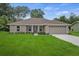 Charming single-story home with lush green lawn, neutral exterior, and attached two-car garage at 27017 Mott Ave, Brooksville, FL 34602
