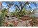 Landscaped backyard with sitting area, pavers, mulched beds, and kayak at 2933 W Alline Ave, Tampa, FL 33611