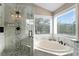 Elegant bathroom featuring a glass enclosed shower, a soaking tub, and bright windows at 2933 W Alline Ave, Tampa, FL 33611