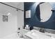 Stylish bathroom featuring navy blue walls, a round mirror, and updated fixtures at 2933 W Alline Ave, Tampa, FL 33611