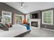 Relaxing bedroom with a cozy fireplace, gray walls, and a light gray carpet at 2933 W Alline Ave, Tampa, FL 33611