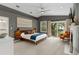 Spacious main bedroom with modern decor, balcony access, a decorative fireplace, and a seating area at 2933 W Alline Ave, Tampa, FL 33611