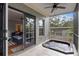 Relaxing screened patio boasts a hot tub, ceiling fan, and view into the home's stylish living area at 2933 W Alline Ave, Tampa, FL 33611