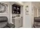 Cozy home bar area features elegant glassware and a sleek gray cabinet with a marble countertop, perfect for entertaining at 3071 Bolt Dr, Palm Harbor, FL 34685