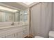 Well-lit bathroom featuring a large mirror, white vanity, and a shower with a curtain at 3071 Bolt Dr, Palm Harbor, FL 34685