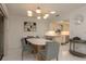 Bright dining area with stylish light fixture, white tile floors, and open access to the kitchen at 3071 Bolt Dr, Palm Harbor, FL 34685