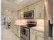 Bright, updated kitchen with stainless steel appliances, marble countertops, and white cabinets for a modern look at 3071 Bolt Dr, Palm Harbor, FL 34685