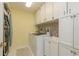 Functional laundry room with white cabinets, modern appliances, and a practical sink at 3071 Bolt Dr, Palm Harbor, FL 34685
