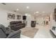 Spacious open-concept living room with tile floors, gray leather couches, and a bar area at 3071 Bolt Dr, Palm Harbor, FL 34685