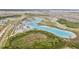 Breathtaking aerial shot showcasing the community lagoon and surrounding landscape with clear blue waters at 31643 Colada Drift Way, Wesley Chapel, FL 33545