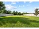 Expansive backyard with lush green lawn, bordered by a white fence, and a seating area at 31643 Colada Drift Way, Wesley Chapel, FL 33545