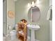Bathroom featuring a stylish pedestal sink, decorative shelving, and modern lighting at 31643 Colada Drift Way, Wesley Chapel, FL 33545