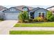 Charming single-story home featuring a manicured lawn and attached two-car garage, perfect for suburban living at 31643 Colada Drift Way, Wesley Chapel, FL 33545