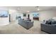 Spacious living room featuring plush seating, carpet flooring, and a large wall-mounted TV at 31643 Colada Drift Way, Wesley Chapel, FL 33545