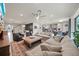 Open-concept living room showcasing ample seating, a large ceiling fan, and seamless flow into dining and kitchen areas at 31643 Colada Drift Way, Wesley Chapel, FL 33545