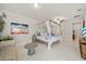 Bright main bedroom with a four poster bed, accent furniture, and en suite bathroom at 31643 Colada Drift Way, Wesley Chapel, FL 33545