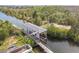 Aerial view of a private boat lift and dock on a serene canal, surrounded by lush greenery and beautiful waterfront property at 3227 Rose Arbor Dr, Hernando Beach, FL 34607