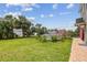 Grassy backyard featuring an above ground pool with a deck, surrounded by palm trees and lush greenery at 3227 Rose Arbor Dr, Hernando Beach, FL 34607