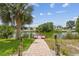 Lush backyard features a brick path leading to a dock and beautiful canal views at 3227 Rose Arbor Dr, Hernando Beach, FL 34607