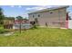 Backyard view of above ground pool and deck featuring lush green grass and mature landscaping at 3227 Rose Arbor Dr, Hernando Beach, FL 34607