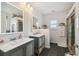 Modern bathroom featuring double sinks, decorative mirrors, tiled floors and glass shower at 3227 Rose Arbor Dr, Hernando Beach, FL 34607