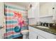 Charming bathroom featuring granite countertop, colorful shower curtain, and decorative storage at 3227 Rose Arbor Dr, Hernando Beach, FL 34607