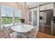 Bright dining area with white furniture, plantation shutters, and stainless steel refrigerator at 3227 Rose Arbor Dr, Hernando Beach, FL 34607