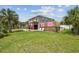 Charming two-story home with a backyard featuring a wooden deck and well-manicured green lawn at 3227 Rose Arbor Dr, Hernando Beach, FL 34607