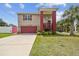 Charming two-story home with a red-colored garage door and a cozy front porch at 3227 Rose Arbor Dr, Hernando Beach, FL 34607