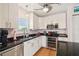 Bright kitchen features white cabinetry, black granite countertops, and stainless steel appliances at 3227 Rose Arbor Dr, Hernando Beach, FL 34607